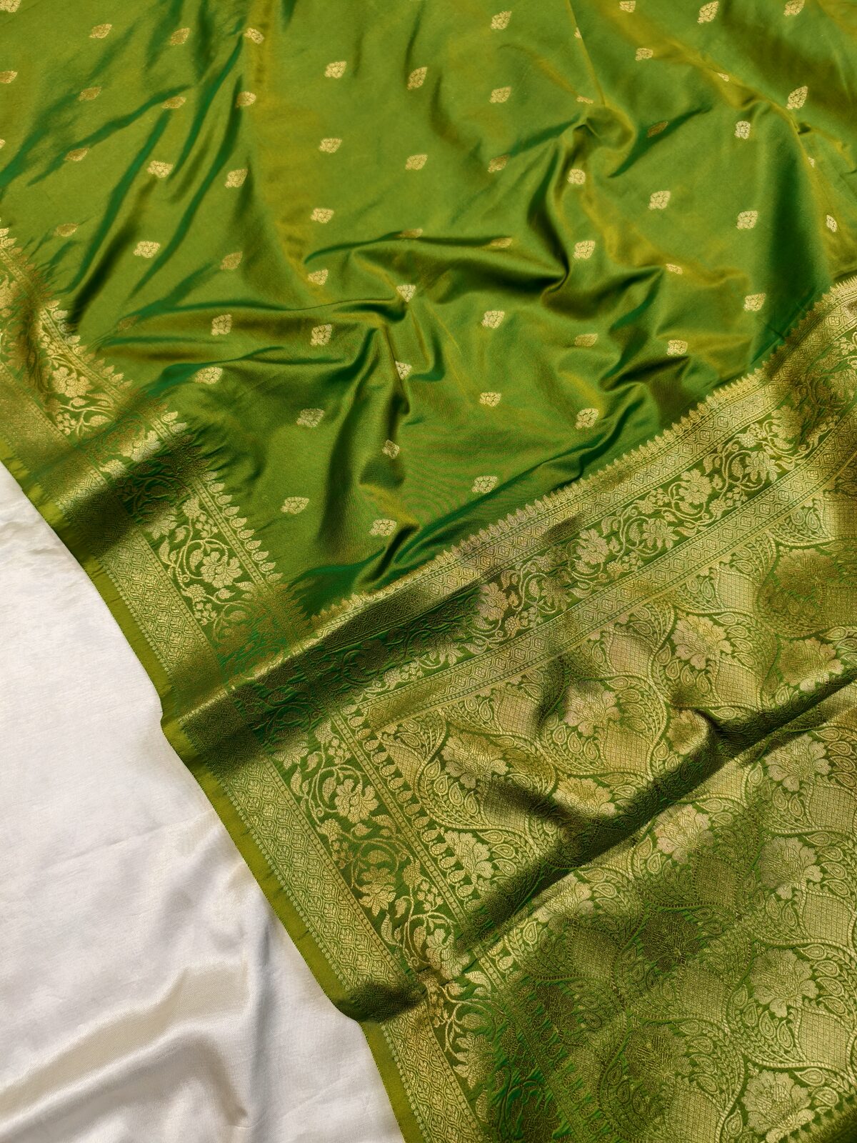 Close-up of a green Banarasi saree with woven gold border
